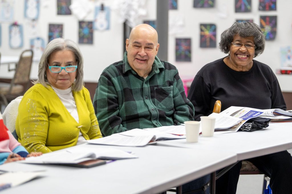 Older adults smiling while looking over materials about aging well.