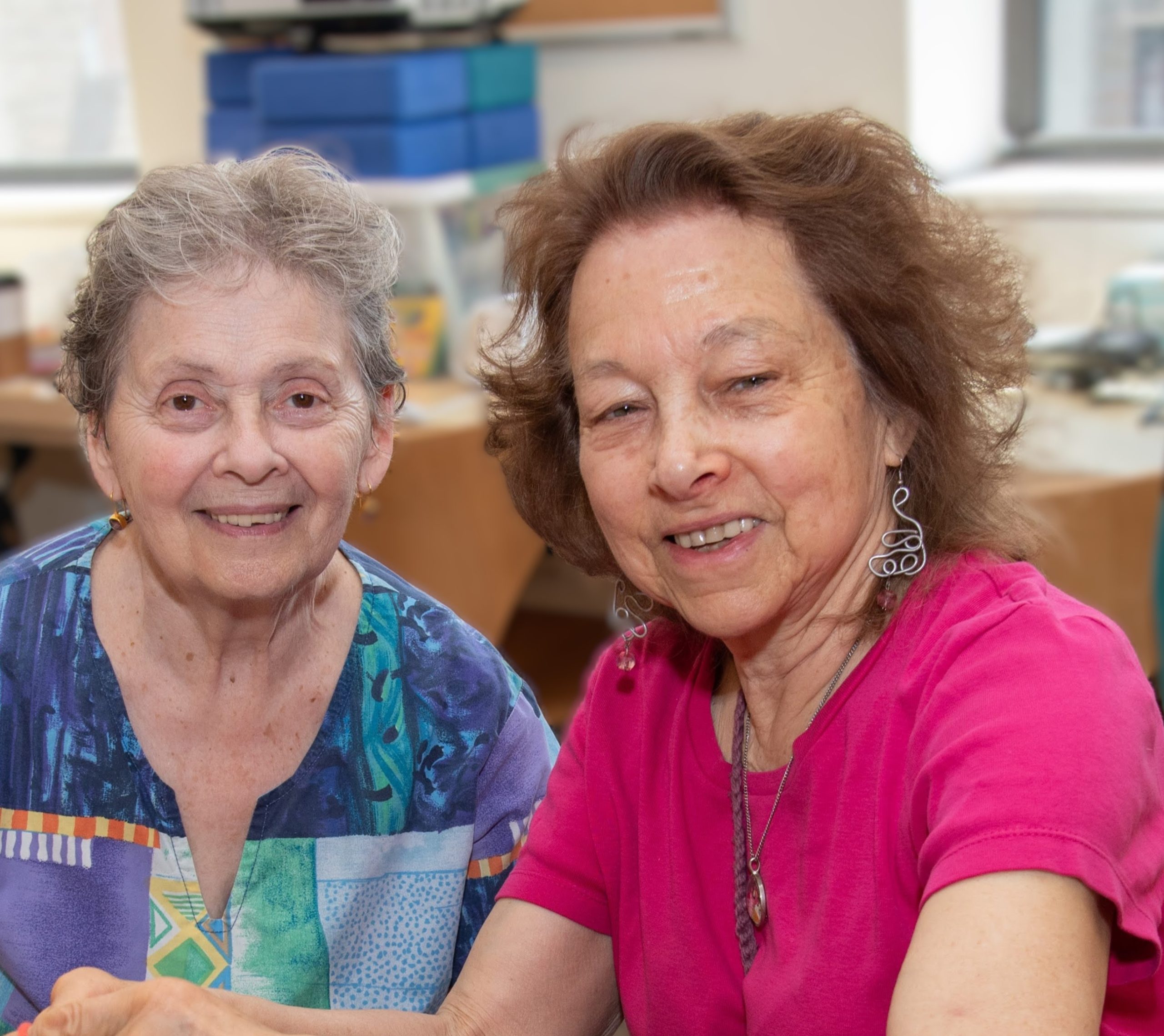 Two older adults looking happy at DOROT.
